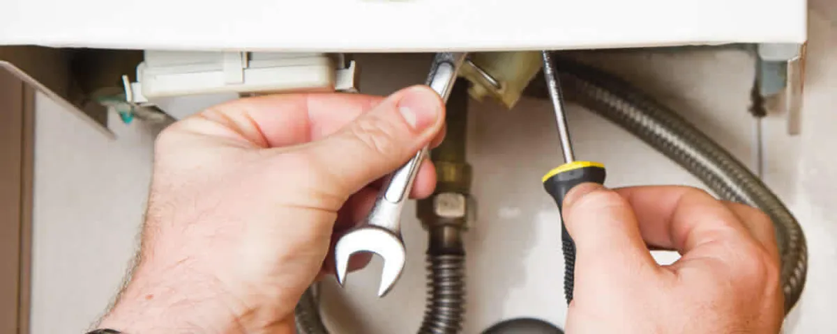 Boiler repair technician tightening pipe fittings and connections in Staten Island, NY