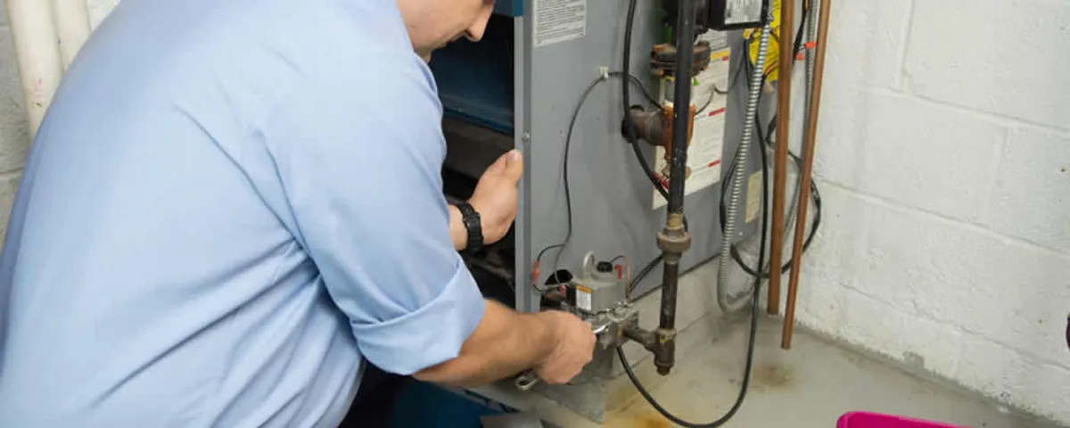 Furnace repair technician inspecting and servicing a home heating system in Staten Island, NY