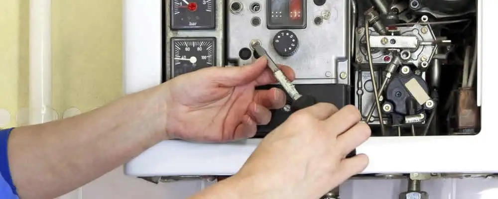 Heating repair technician adjusting boiler controls and components in Staten Island, NY
