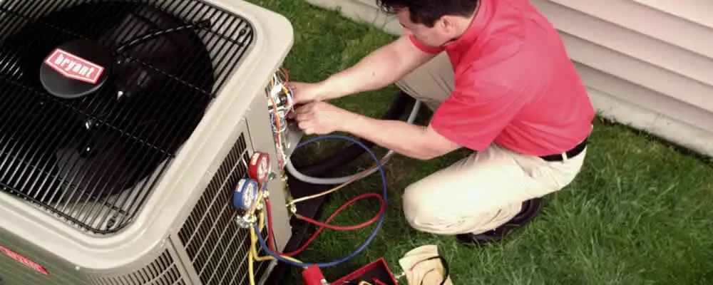 HVAC technician servicing an outdoor air conditioner unit in Staten Island, NY