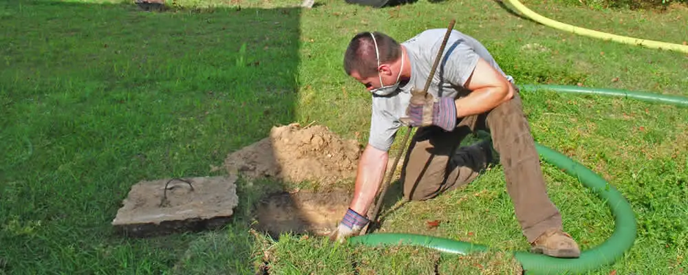 Septic pumping technician servicing a residential septic tank in Staten Island, NY