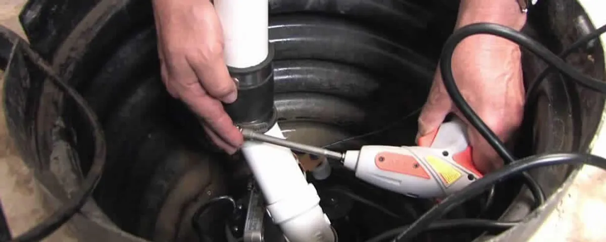 Sump pump installation technician connecting PVC discharge piping in Staten Island, NY