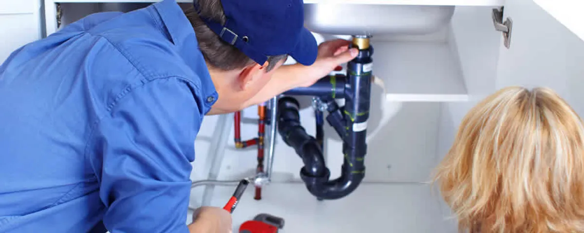 Plumber repairing under-sink drain pipes and fittings in Staten Island, NY
